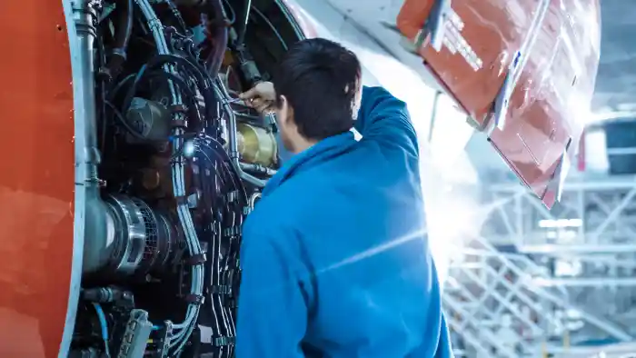 Aircraft maintenance engineer inspecting a jet engine in a hangar in Pakistan