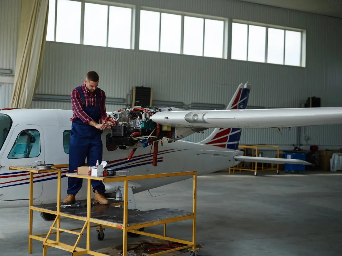 Aircraft engine with cowling open during maintenance in a hangar