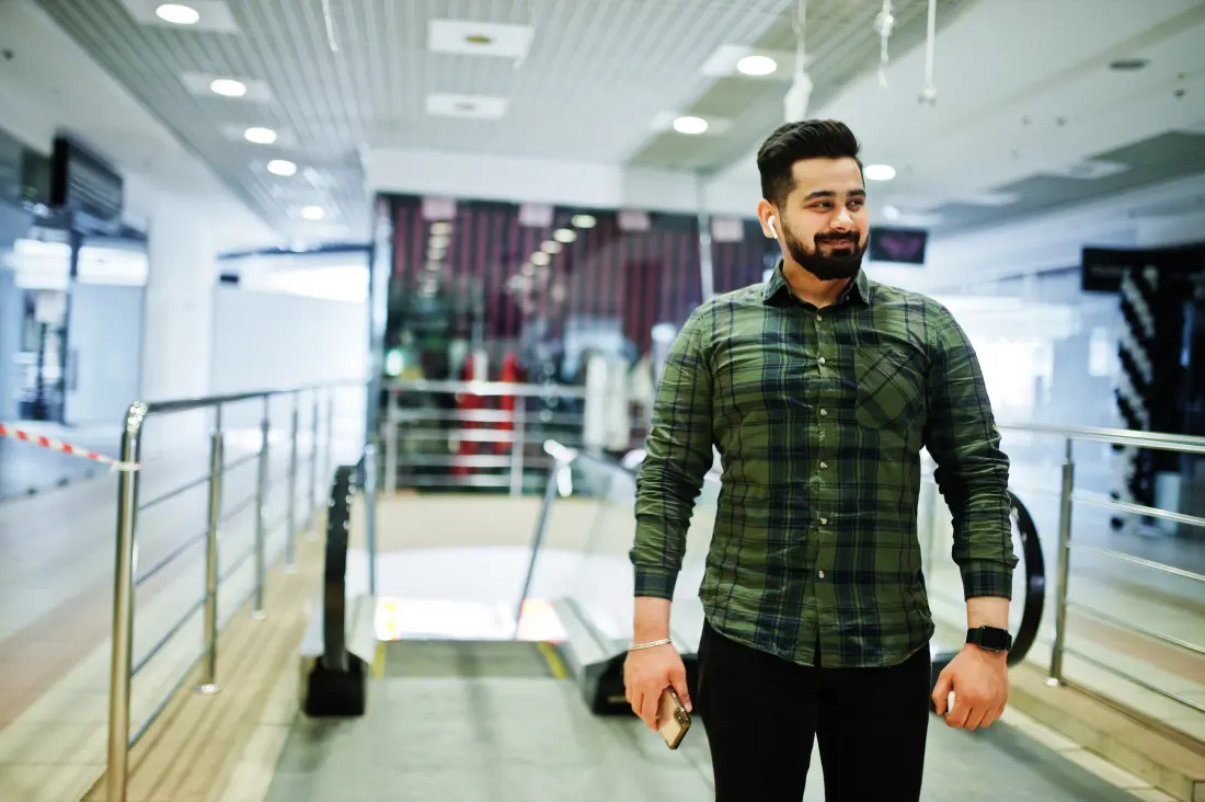 Young South Asian man researching an aircraft maintenance engineering career on his phone