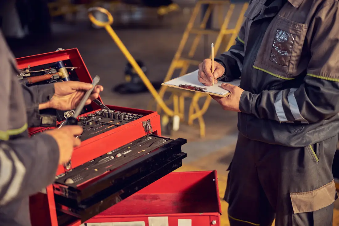 Aircraft maintenance technicians with a toolbox and clipboard during hangar training