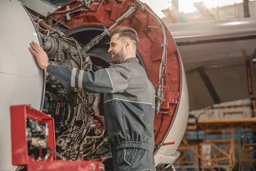 Aircraft mechanic working on an open jet engine in a hangar, the hands-on work covered by Category B1 modules