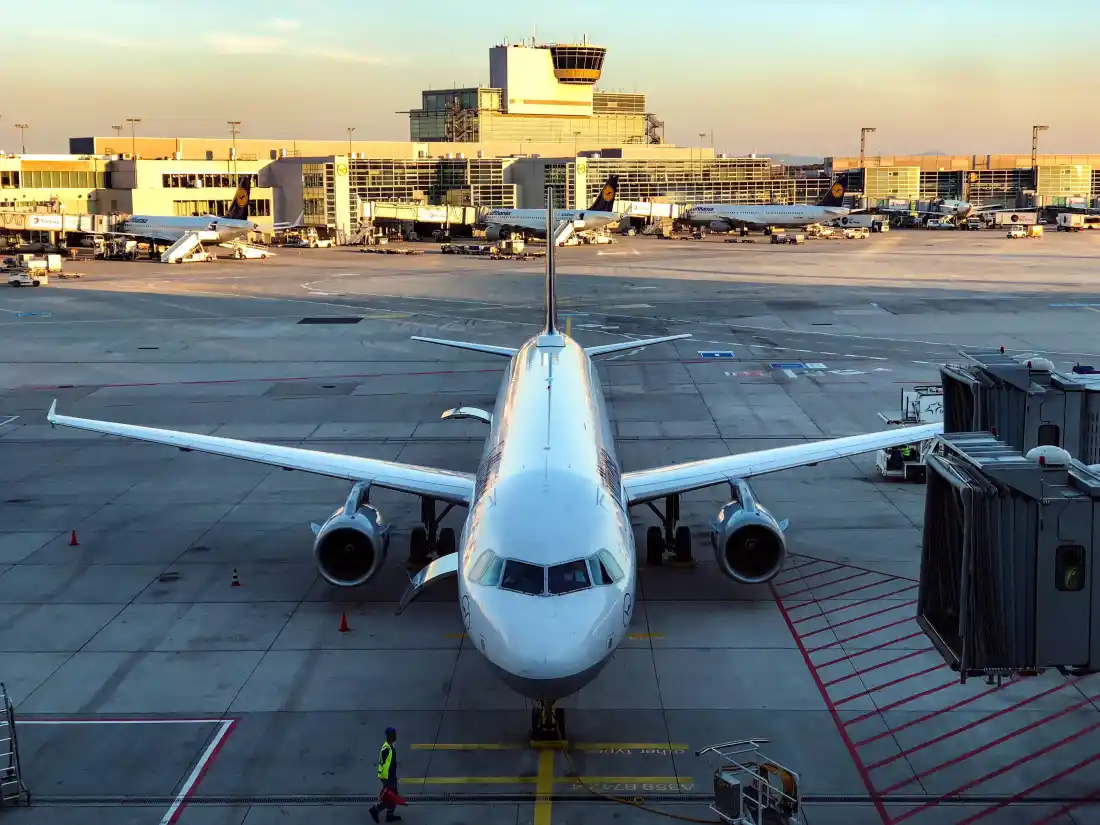 Passenger airliner parked at an airport terminal gate at sunset