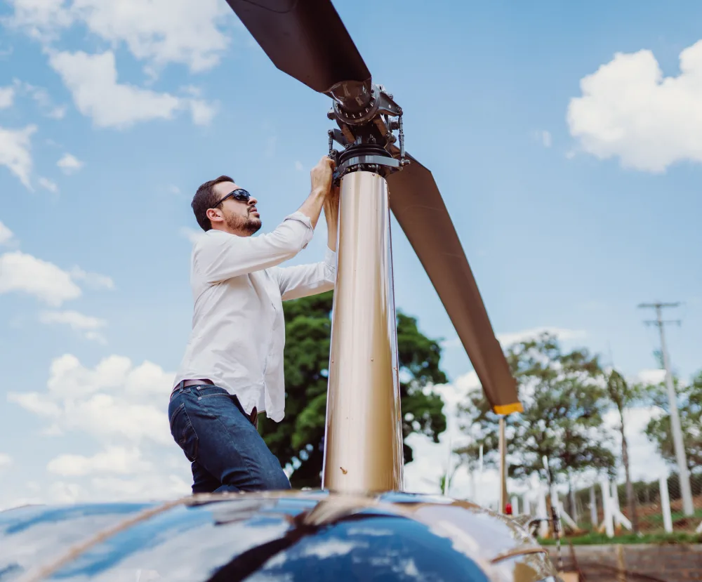 Mechanic inspecting a helicopter main rotor blade and rotor head