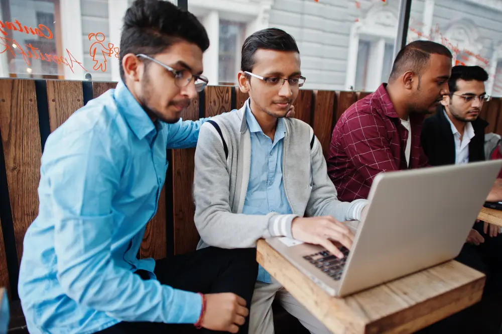 South Asian students studying together at a laptop in a classroom