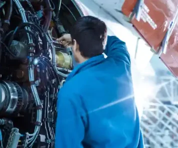 Aircraft maintenance engineer inspecting a jet engine in a hangar in Pakistan
